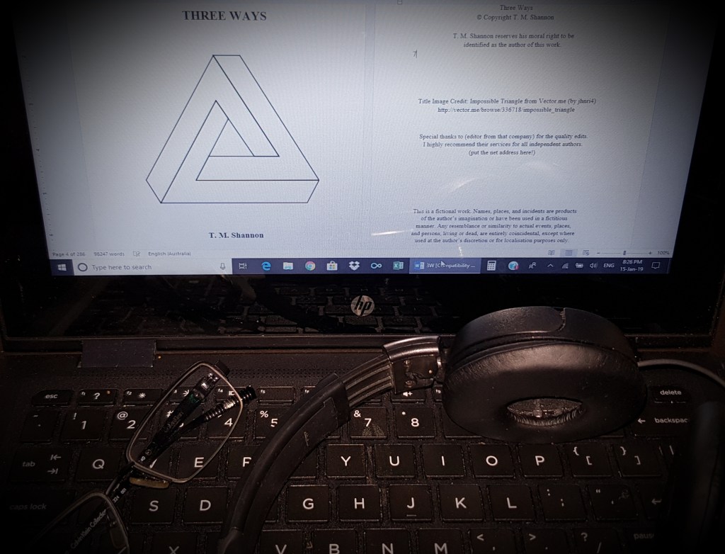 A laptop with a pair of glasses and headphones on the keyboard, with the screen showing the title and attributions page of the book Three Ways, which features the Impossible Triangle, a 3D image a triangle where the sides fold into each other